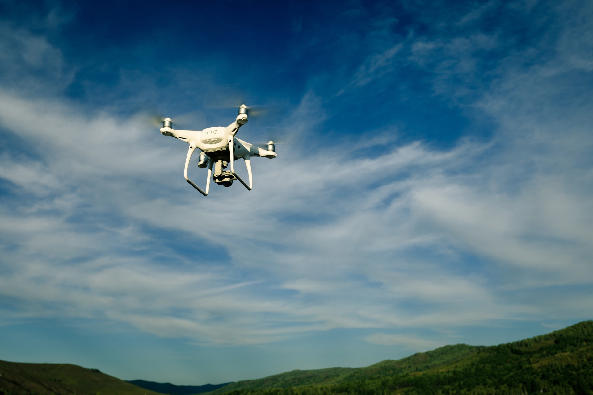 drone flying in the air over forest