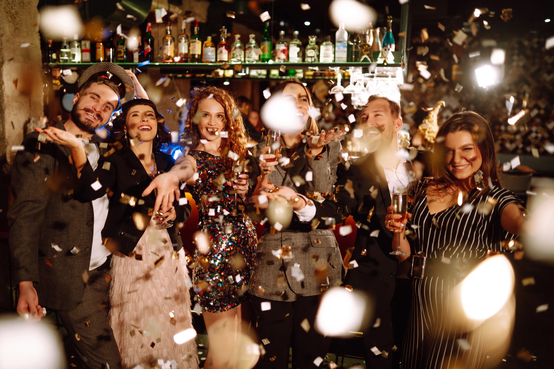 Confetti party. Have fun together. Group of happy people throwing confetti while enjoying party.